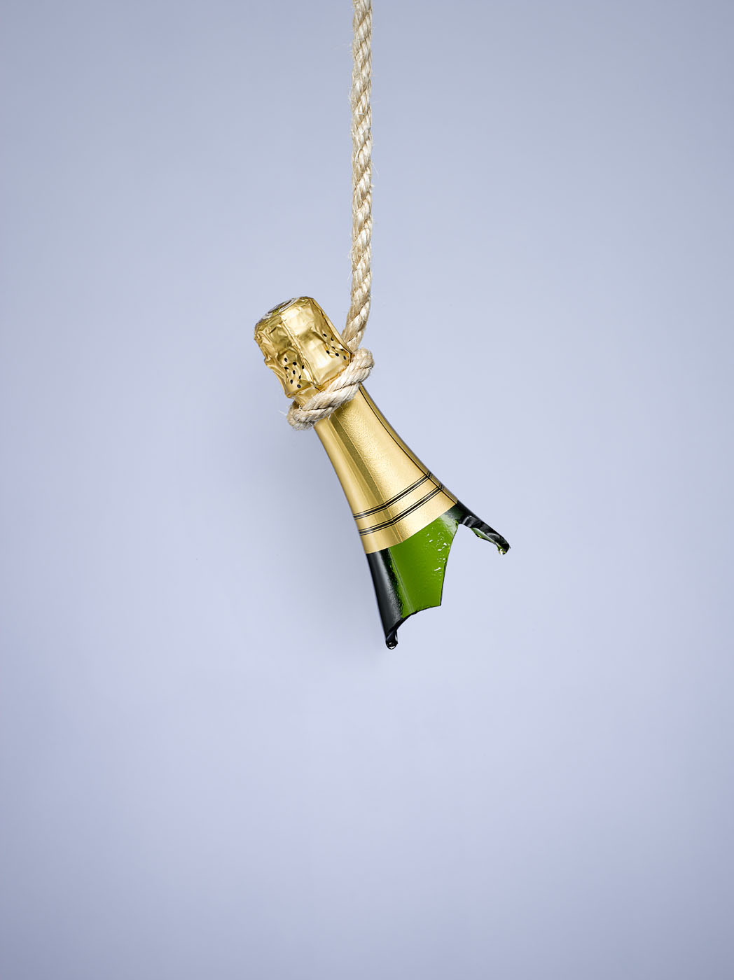 Smashed champagne bottle on blue by Alexander Kent London based still life and product photographer.