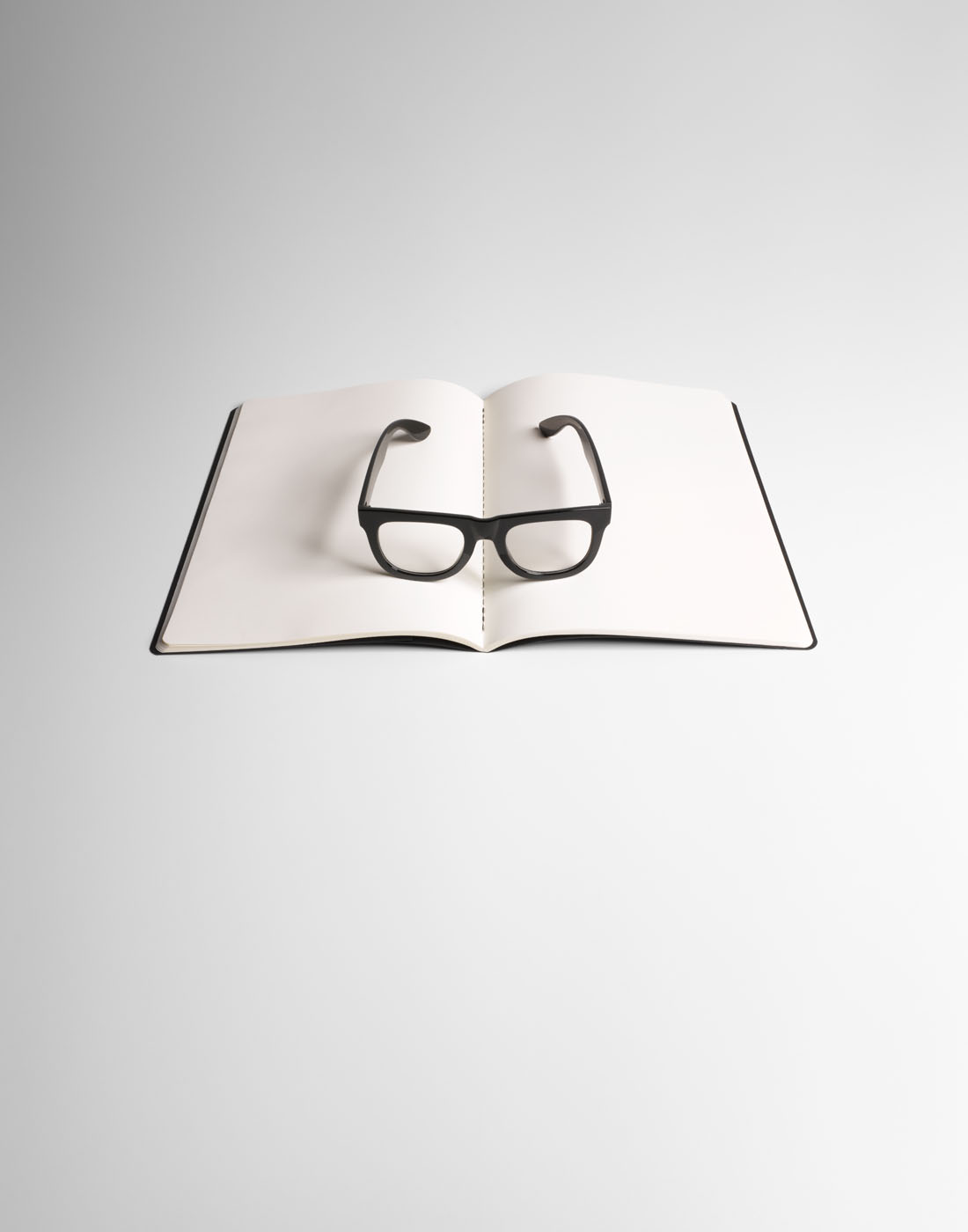 Reading glasses on notepad by Alexander Kent London based still life and product photographer.