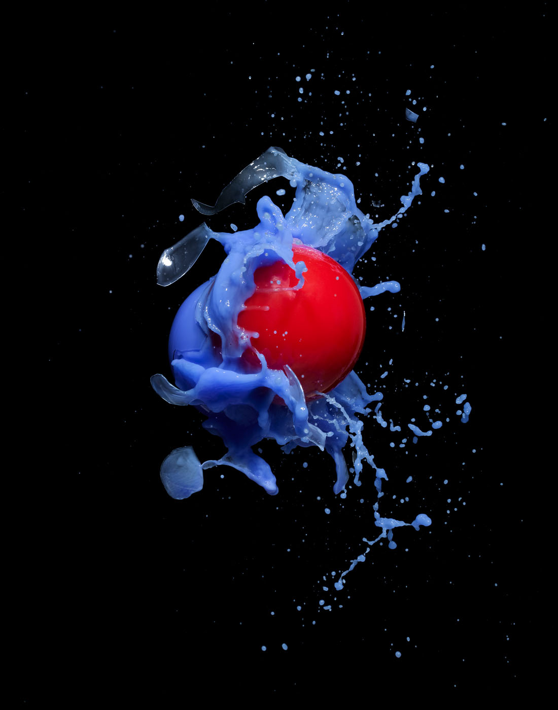 Red and blue balls exploding in photo studio by Alexander Kent London based still life and product photographer.